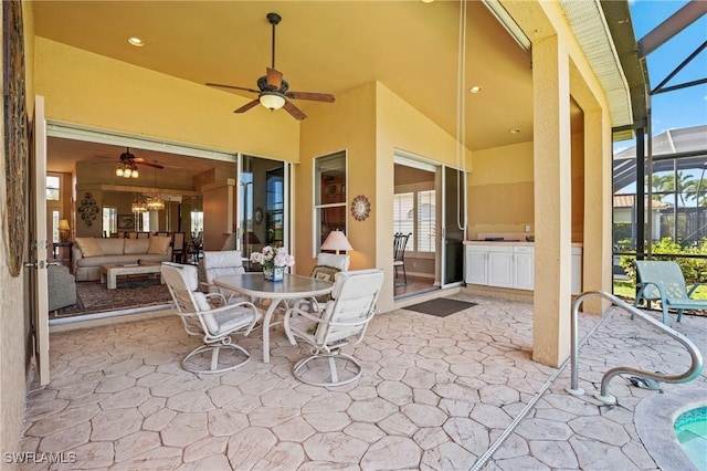 view of patio / terrace featuring a lanai, outdoor dining area, a ceiling fan, and outdoor lounge area