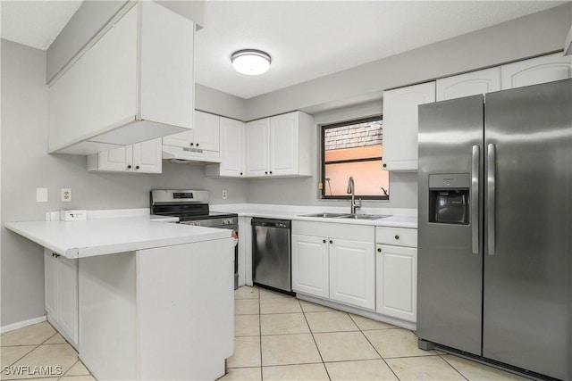 kitchen featuring appliances with stainless steel finishes, a peninsula, under cabinet range hood, a sink, and light tile patterned flooring