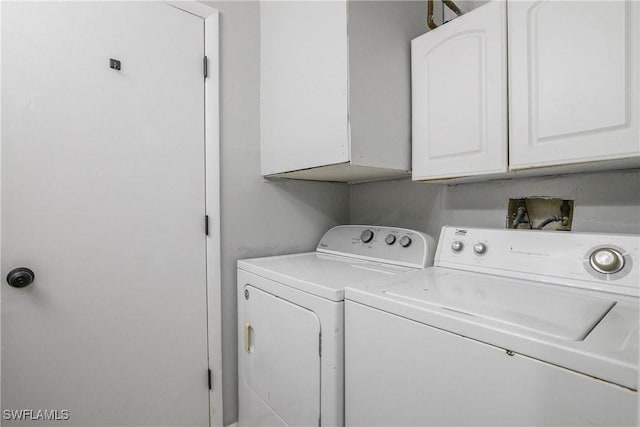 washroom with cabinet space and washing machine and clothes dryer