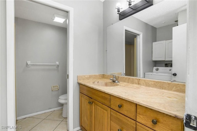 bathroom with washer / dryer, baseboards, toilet, tile patterned flooring, and vanity