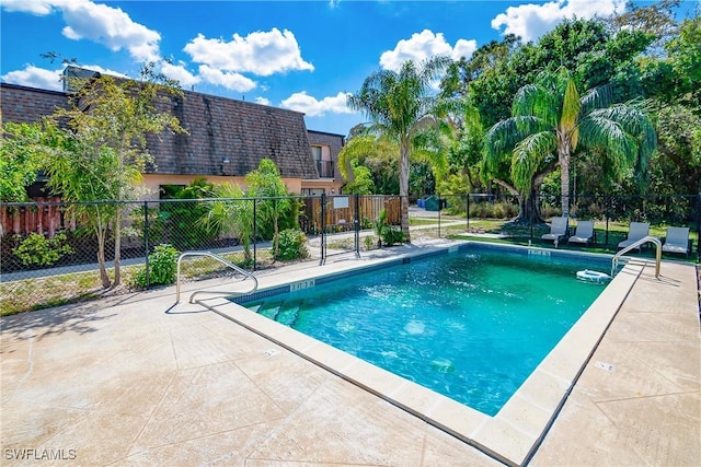 pool with a patio area and fence