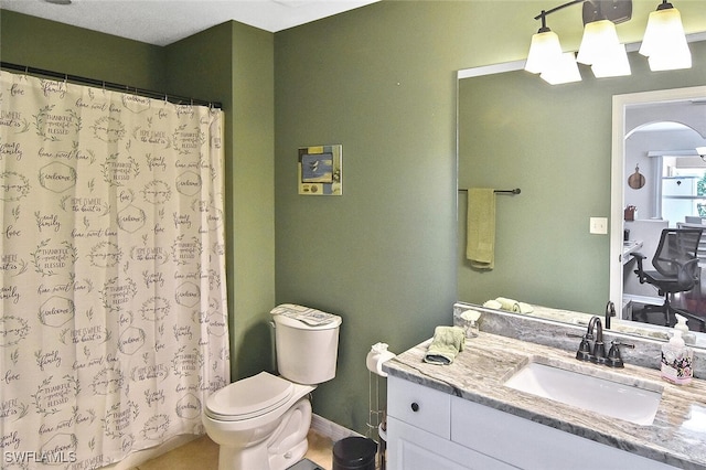 bathroom with curtained shower, vanity, and toilet