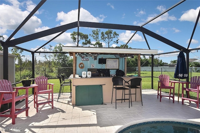 view of patio / terrace with glass enclosure, fence, and outdoor dry bar