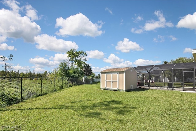 view of yard featuring glass enclosure, a fenced backyard, a storage unit, and an outbuilding