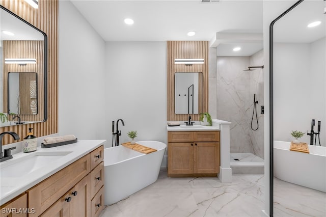 bathroom featuring marble finish floor, two vanities, a sink, and a marble finish shower