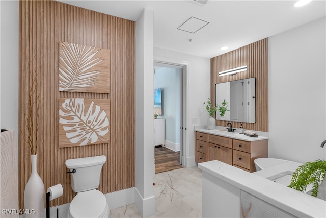 bathroom featuring toilet, recessed lighting, vanity, baseboards, and marble finish floor