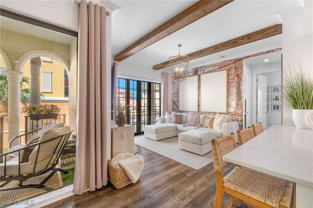 interior space featuring dark wood-style floors, ornate columns, beam ceiling, and an inviting chandelier