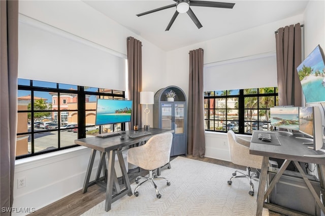 home office with wood finished floors, a ceiling fan, and baseboards