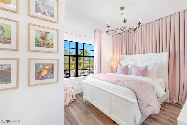 bedroom featuring a chandelier and wood finished floors