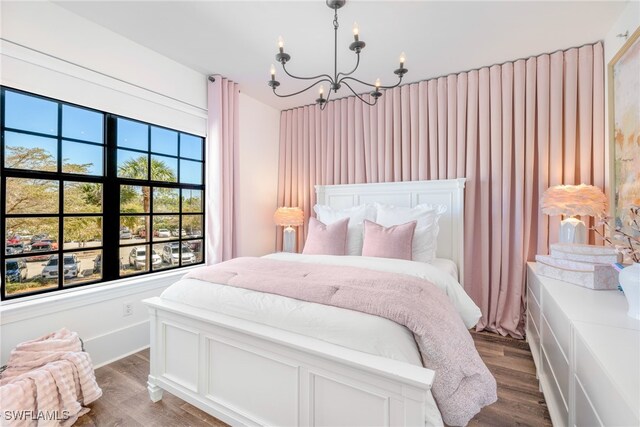 bedroom with dark wood-type flooring and an inviting chandelier