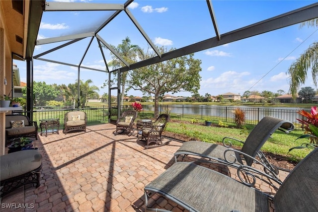 view of patio / terrace with a water view, fence, and a lanai