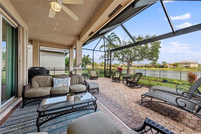 view of patio featuring a water view, grilling area, ceiling fan, fence, and a lanai