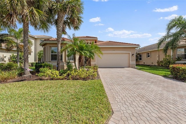 mediterranean / spanish-style house featuring a front lawn, decorative driveway, an attached garage, and stucco siding