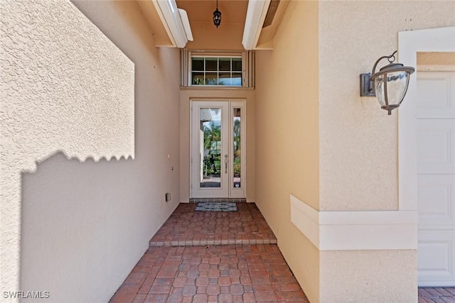 property entrance with a garage and stucco siding