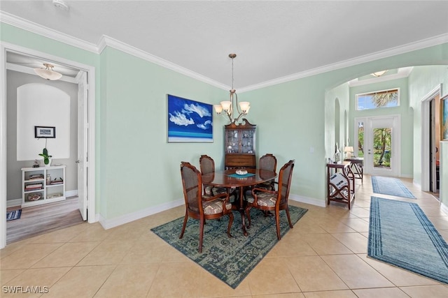 dining space featuring arched walkways, light tile patterned flooring, and crown molding