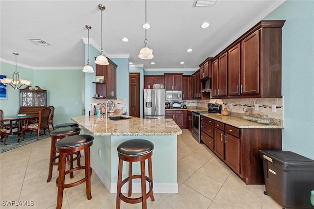 kitchen featuring visible vents, appliances with stainless steel finishes, a breakfast bar area, a peninsula, and light stone countertops