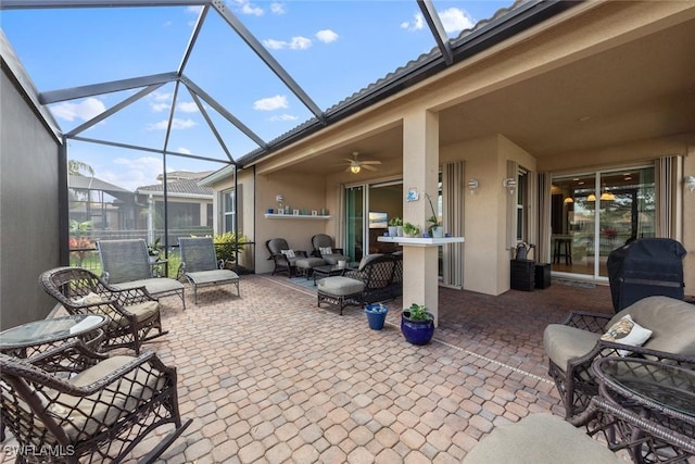 view of patio / terrace with a ceiling fan, glass enclosure, and grilling area