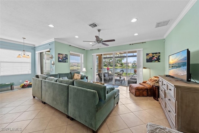 living area with light tile patterned floors, visible vents, and crown molding