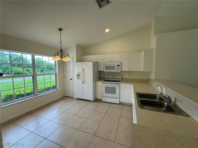 kitchen with light countertops, visible vents, vaulted ceiling, a sink, and white appliances