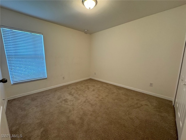 carpeted empty room with baseboards