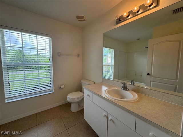 bathroom featuring a shower, visible vents, toilet, vanity, and tile patterned floors