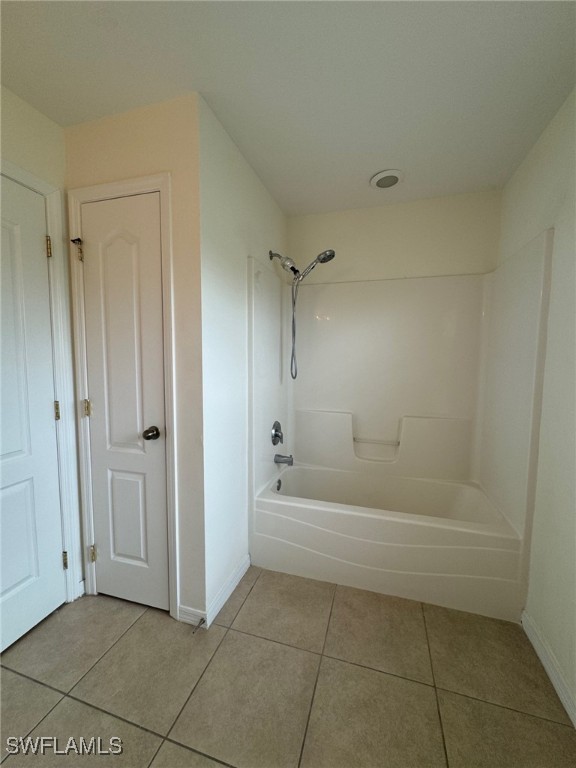 full bathroom featuring baseboards, tub / shower combination, and tile patterned floors