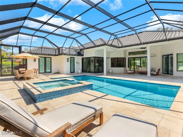 view of pool with a ceiling fan, glass enclosure, an outdoor hangout area, a patio area, and a pool with connected hot tub