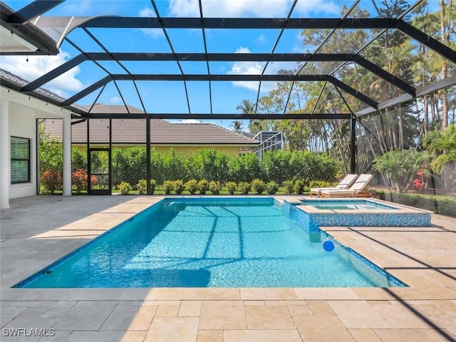 view of pool featuring a patio area, a lanai, and a pool with connected hot tub