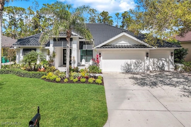 ranch-style home featuring concrete driveway, a tile roof, an attached garage, a front lawn, and stucco siding