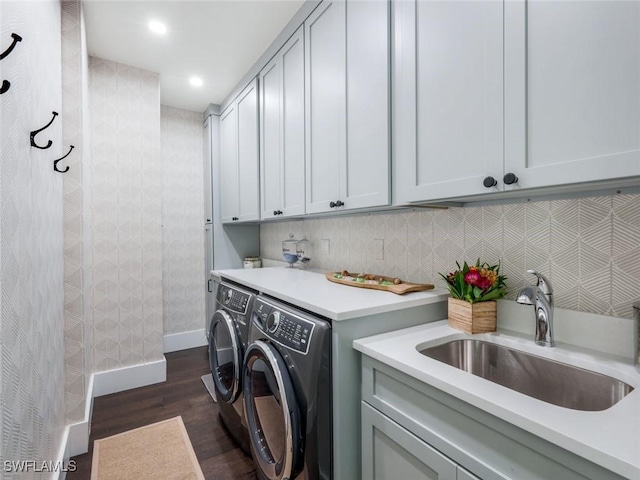 clothes washing area featuring dark wood-style floors, recessed lighting, cabinet space, washing machine and dryer, and a sink