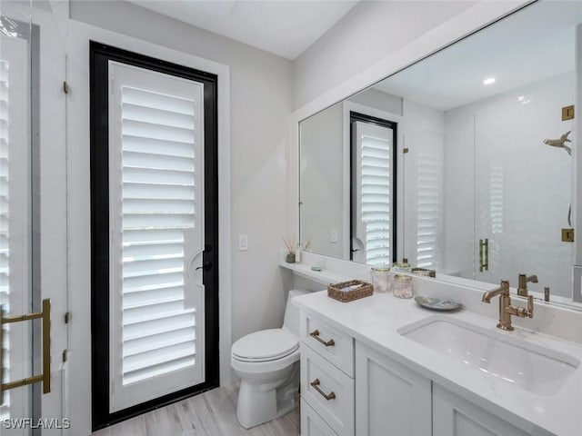 bathroom featuring toilet, wood finished floors, and vanity