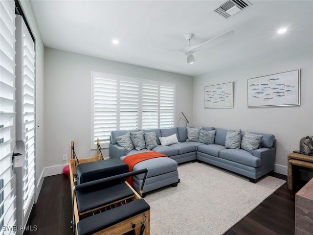 living room with baseboards, ceiling fan, visible vents, and wood finished floors