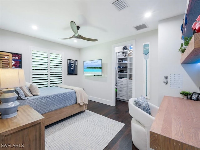 bedroom featuring dark wood-style floors, recessed lighting, a walk in closet, and visible vents