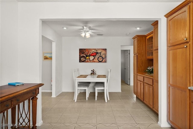 dining area with light tile patterned flooring, ceiling fan, visible vents, and baseboards