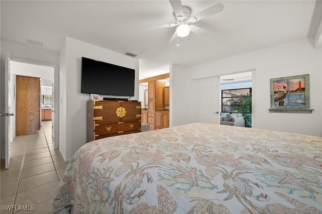 bedroom featuring a ceiling fan, visible vents, a textured ceiling, and light tile patterned flooring