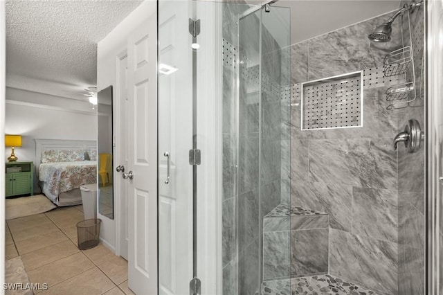 ensuite bathroom with a textured ceiling, tile patterned flooring, connected bathroom, and a shower stall