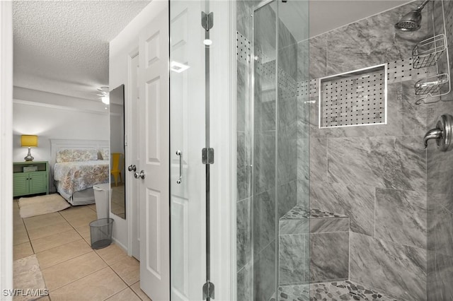 full bath featuring tile patterned floors, a shower stall, a textured ceiling, and ensuite bathroom