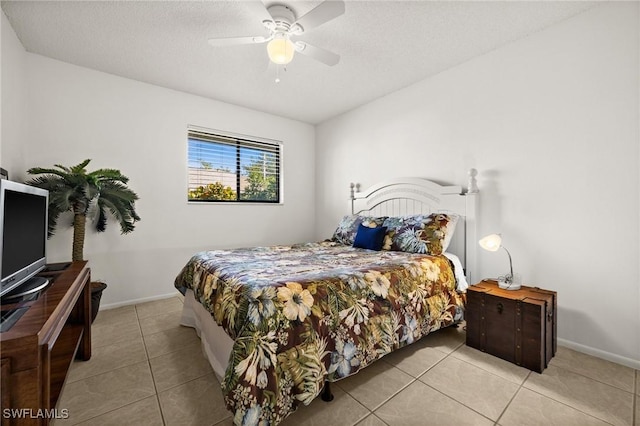 bedroom with a textured ceiling, tile patterned flooring, a ceiling fan, and baseboards