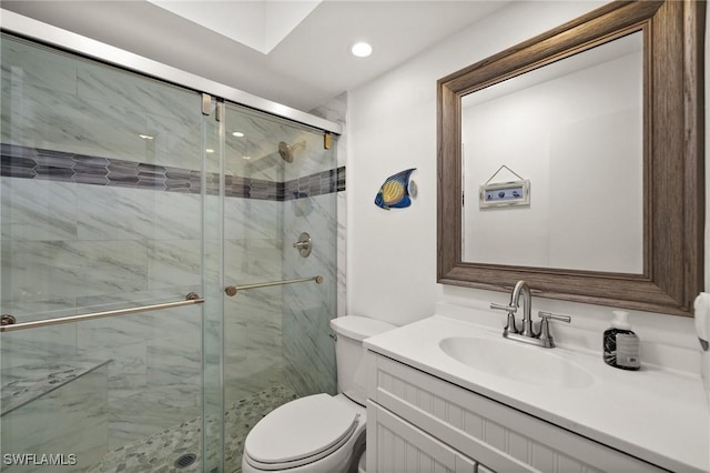 bathroom with toilet, a shower stall, and vanity