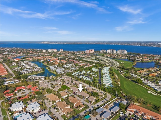 birds eye view of property with view of golf course and a water view