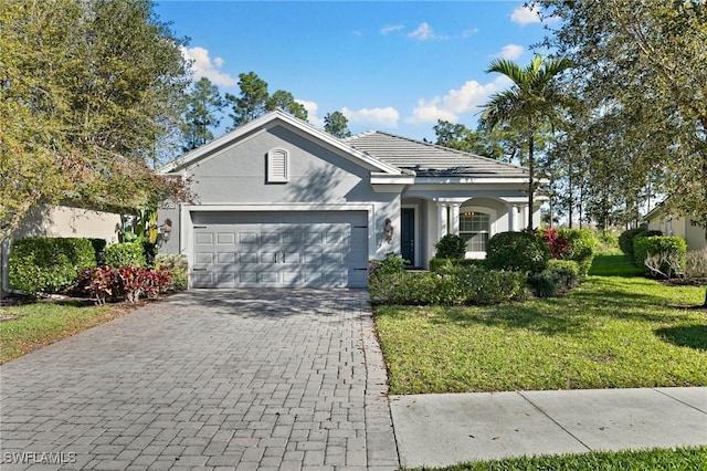 ranch-style house with a garage, a front lawn, decorative driveway, and stucco siding