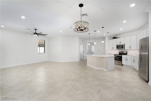 kitchen with a center island with sink, visible vents, appliances with stainless steel finishes, open floor plan, and ornamental molding