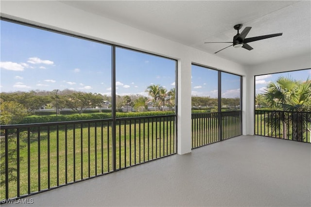 unfurnished sunroom with ceiling fan