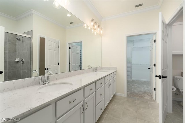 bathroom featuring crown molding, a sink, toilet, and double vanity