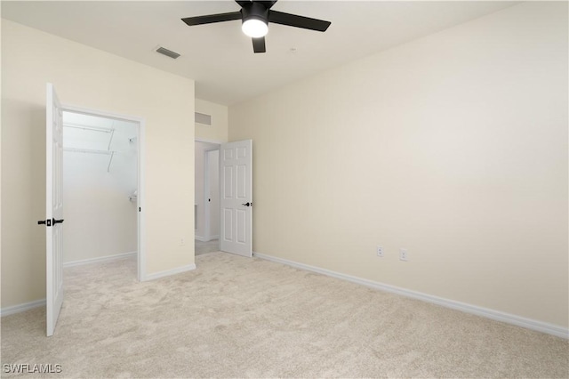 unfurnished bedroom with baseboards, visible vents, a closet, and light colored carpet