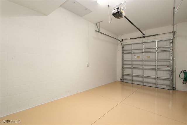 garage featuring a garage door opener and concrete block wall