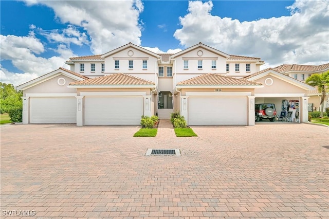 mediterranean / spanish house with an attached garage, a tile roof, decorative driveway, and stucco siding