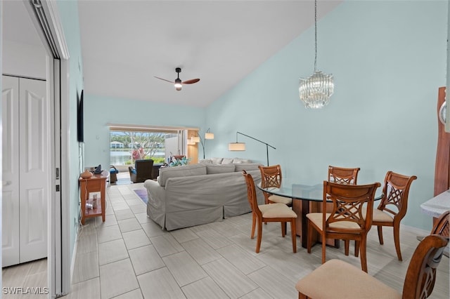 dining room with high vaulted ceiling and ceiling fan with notable chandelier