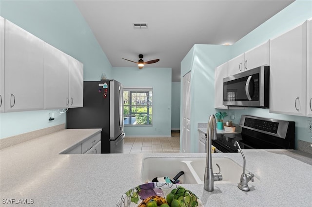 kitchen with appliances with stainless steel finishes, light countertops, white cabinets, and visible vents