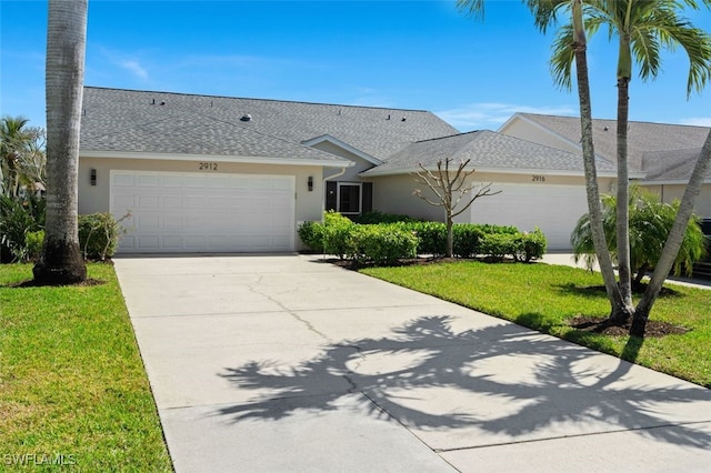 ranch-style house with driveway, stucco siding, roof with shingles, an attached garage, and a front yard